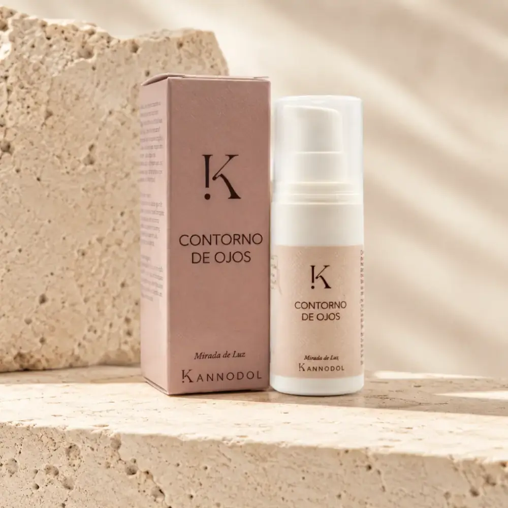 Envase del Contorno de Ojos de Kannodol junto a una mujer aplicando el producto con el dedo anular en la zona periocular